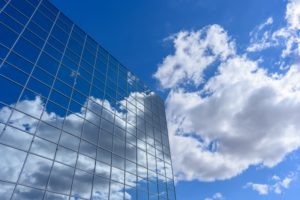 Blue sky with clouds reflecting in glass building