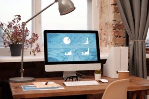 laptop on desk displaying graphs on a turqoise bckground