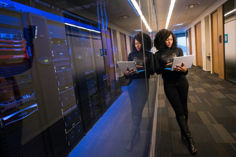 Woman standing outside server room with laptop