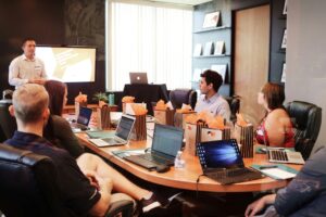 Group of people at a table receiving training with laptops open