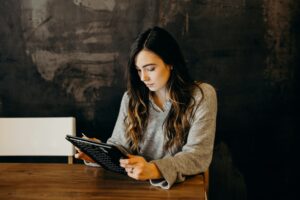 Femaele with long dark hairworking on a laptop