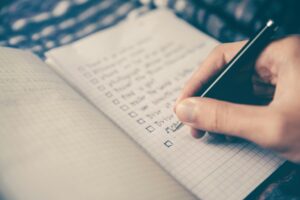 hand holding a pen writing a to do list