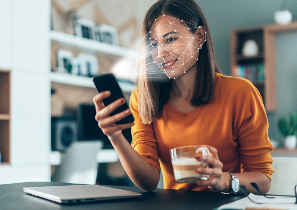 Woman smiling into mobile phone conducting scan of of face