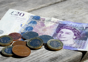 UK money scattered on a desk £20 note and loose change